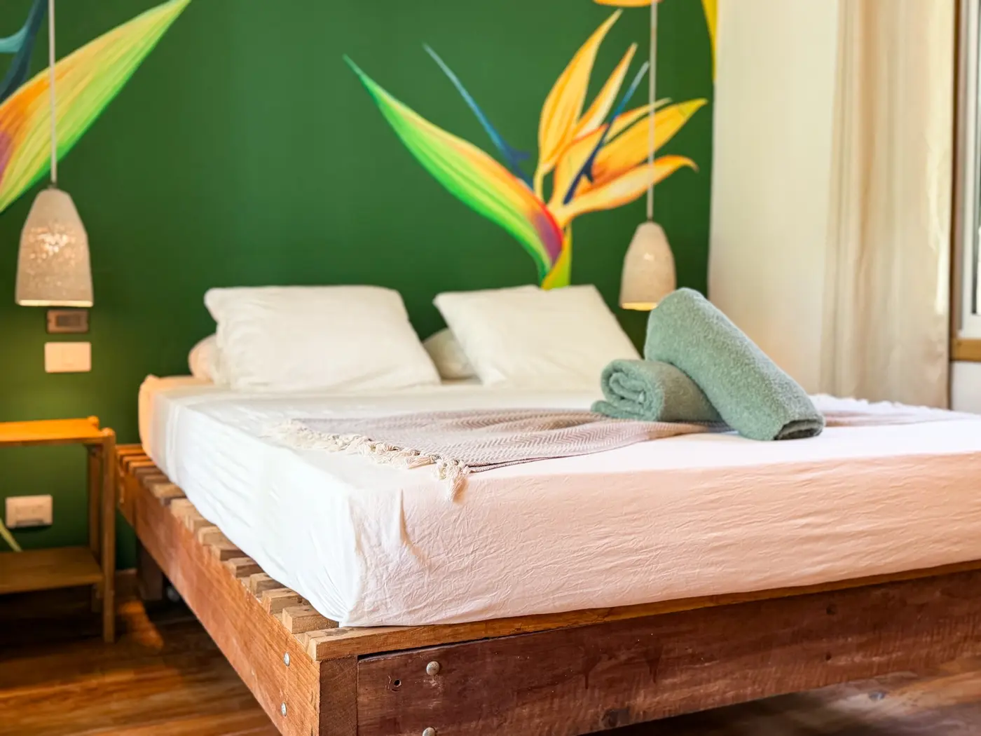 Queen-size bed and hand-painted tropical wall in Casa Verde